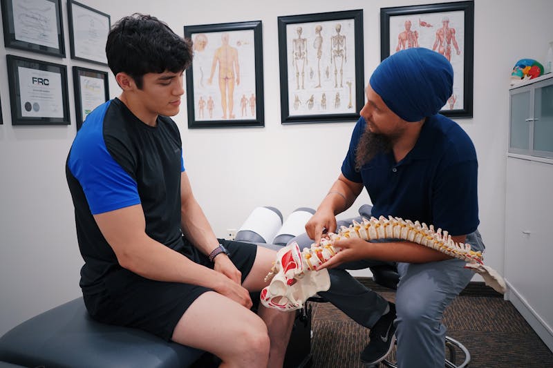 Bel Ağrısı Neden Olur? Yaygın Nedenler ve Tedavi Rehberi 2 Doktor omurga modeli ile hastasına bel sorununu anlatıyor